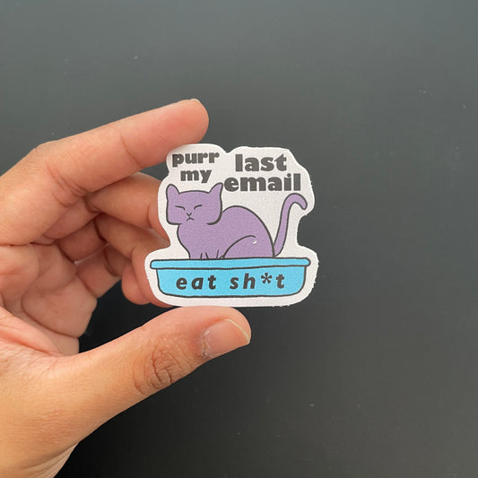 Hand holding a sticker with a purple cat illustration and text on a dark background
