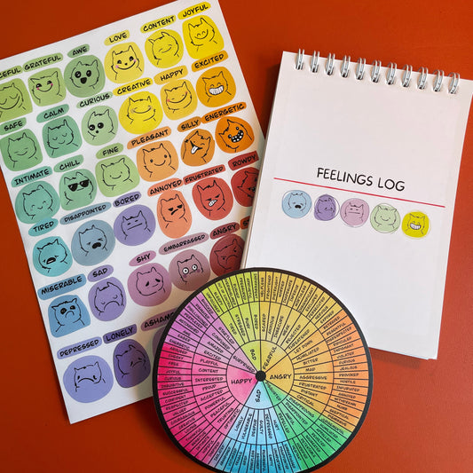 Emotions log book, sticker sheet, and emotion wheel on a red background